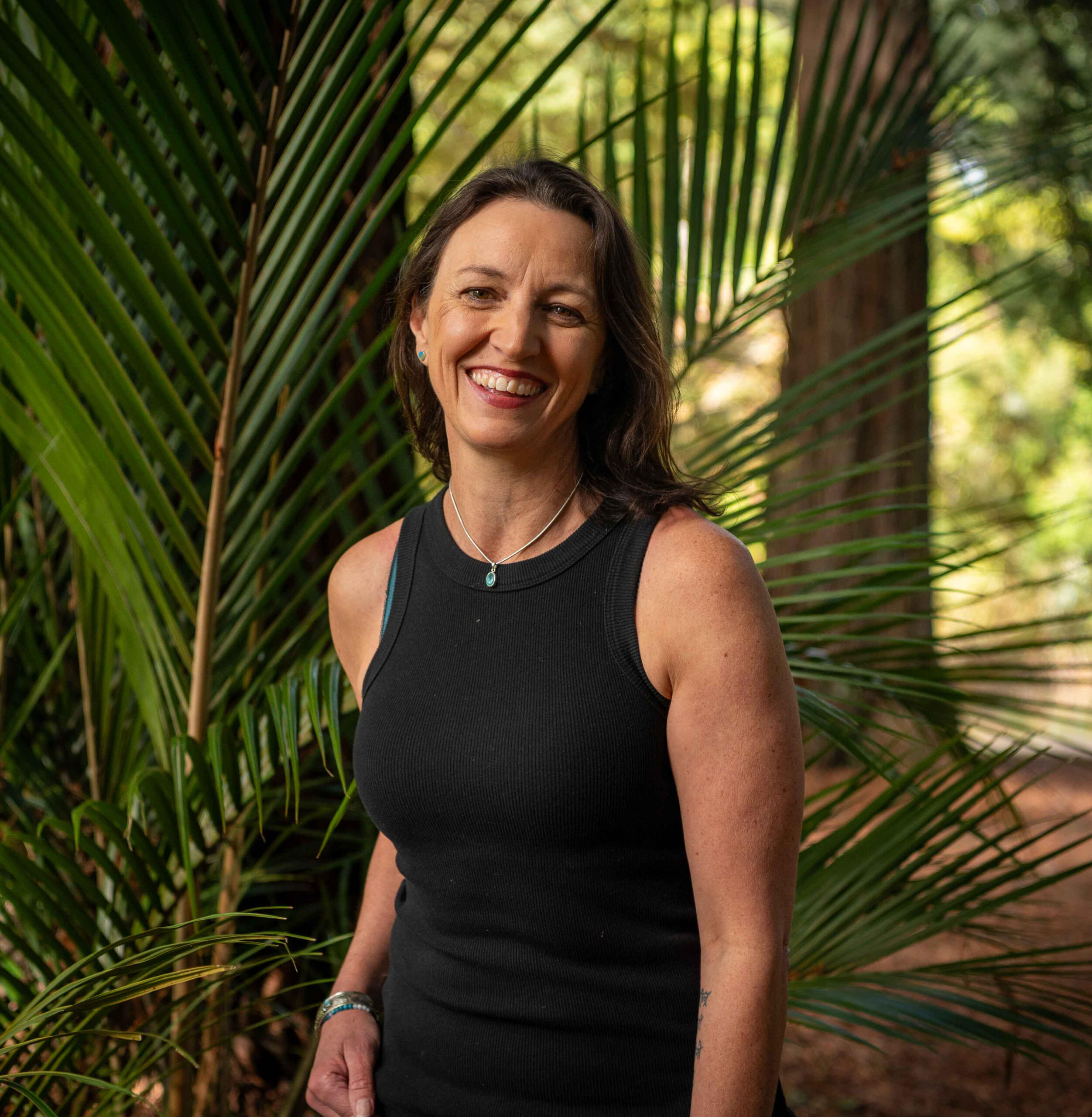 Sarah Lucas, New Plymouth council mayor and Kohanga Moa ward candidate, standing in front of a nikau palm